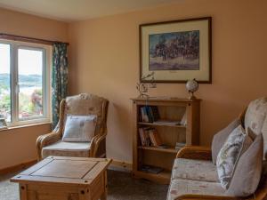 a living room with two chairs and a table and a window at Chalet Skye Garden Accommodation by Interhome in Portree