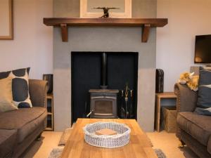 - un salon avec une cheminée et une table en bois dans l'établissement Holiday Home An Caladh by Interhome, à Harlosh
