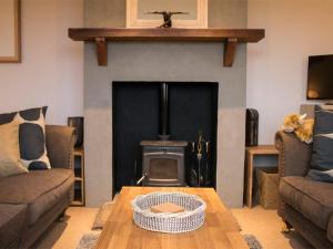 a living room with a fireplace and a wooden table at Holiday Home An Caladh by Interhome in Harlosh