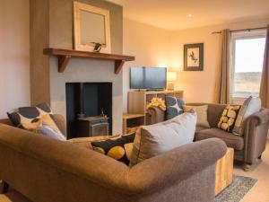 a living room with two couches and a fireplace at Holiday Home An Caladh by Interhome in Harlosh