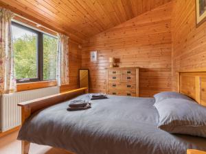 a bedroom with a bed in a wooden cabin at Chalet Loch Side Lodge 8 by Interhome in Kinross