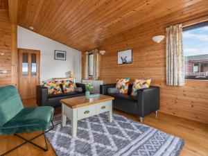 een woonkamer met 2 banken en een tafel bij Chalet Loch Side Lodge 8 by Interhome in Kinross