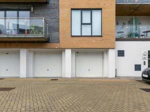 a row of four garage doors on a building at Apartment The Saltings by Interhome in St Austell