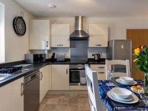een keuken met een tafel met een blauwe tafeldoek bij Apartment Stones Throw by Interhome in St Austell