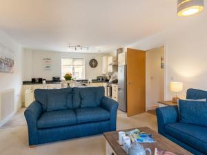 een woonkamer met twee blauwe banken en een keuken bij Apartment Stones Throw by Interhome in St Austell