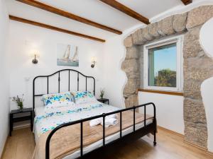 a bedroom with a bed and a window at Holiday Home Paesana Heritage House by Interhome in Vrbnik