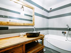 a bathroom with striped walls and a sink and a tub at Apartment Torrita di Canazei by Interhome in Alba di Canazei