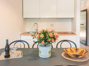uma cozinha com uma mesa com um vaso de flores em Apartment Trilo Garden by Interhome em Marina di Bibbona