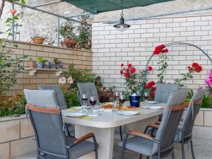 a table and chairs in a patio with flowers at Apartment Villa Andro by Interhome in Selca