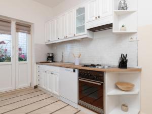a kitchen with white cabinets and a stove top oven at Apartment Villa Andro by Interhome in Selca