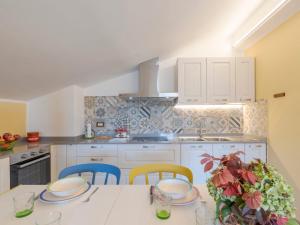 una cocina con armarios blancos y una mesa con sillas. en Apartment Gabriella by Interhome, en Pontedassio