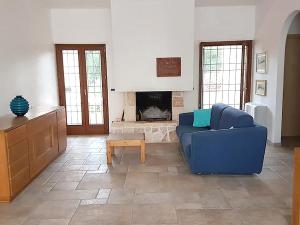 ein Wohnzimmer mit einem blauen Sofa und einem Kamin in der Unterkunft Holiday Home La Badessa by Interhome in Ostuni