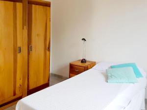 ein Schlafzimmer mit einem weißen Bett und einem blauen Kissen darauf in der Unterkunft Holiday Home La Badessa by Interhome in Ostuni