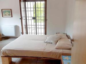 Bett mit weißer Bettwäsche und Kissen in einem Zimmer in der Unterkunft Holiday Home La Badessa by Interhome in Ostuni