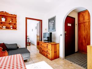 ein Wohnzimmer mit einem Sofa und einem TV auf einer Kommode in der Unterkunft Apartment Cesa Minach-3 by Interhome in Alba di Canazei