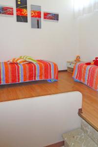 two beds in a room with wooden floors at Apartment Primula by Interhome in Bibione