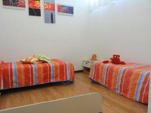 two beds in a room with a teddy bear on them at Apartment Primula by Interhome in Bibione