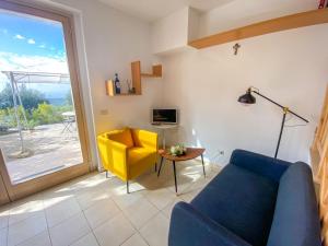 salon z niebieską kanapą i żółtym krzesłem w obiekcie Holiday Home Casa Chiara by Interhome w mieście Castellina in Chianti