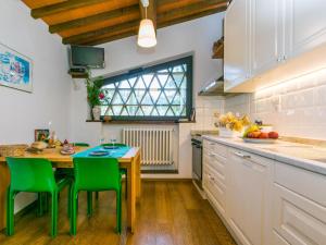 uma cozinha com uma mesa de madeira e cadeiras verdes em Apartment L'Angolo di Uzzano by Interhome em Greve in Chianti