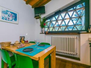 a dining room table with green chairs and a window at Apartment L'Angolo di Uzzano by Interhome in Greve in Chianti +70 photos