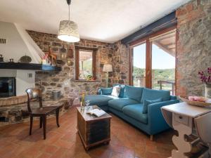 uma sala de estar com um sofá azul e uma parede de pedra em Holiday Home Meridiana by Interhome em Cana