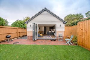 een huis met een patio en een hek bij 4 Eureka Waldringfield Air Manage Suffolk in Woodbridge