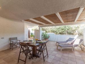 un patio con mesa de madera y sillas en Holiday Home Morellino by Interhome, en Aglientu