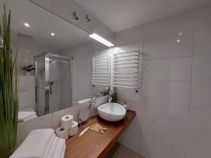 een witte badkamer met een wastafel en een spiegel bij Apartament Sienna Czarna Góra STUBAI 29 in Siena