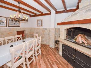 a dining room with a fireplace and a table and chairs at Holiday Home Zorka by Interhome in Stankovci