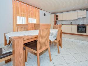 a kitchen with a wooden table and chairs at Holiday Home Zorka by Interhome in Stankovci