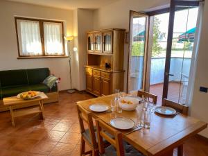 ein Wohnzimmer mit einem Holztisch und einem Esszimmer in der Unterkunft Vela Ferienwohnung mit Dachterrasse in Colico