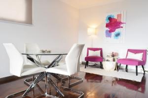 a dining room with a glass table and two chairs at Design Gardens, a Home in Madeira in Funchal