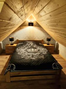 ein großes Bett in einem Zimmer mit Holzdecke in der Unterkunft Willa "KomaNcza" Szczawnica E-Apartamenty in Szczawnica