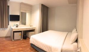 ein Hotelzimmer mit einem Bett und einem Waschbecken in der Unterkunft Ten Stars Hotel in Bangkok