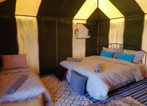 a bedroom with two beds in a tent at Bivouac Draa in Zagora