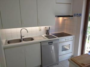 a kitchen with a sink and a stove at 2 bedroom app, close to the beach and Plopsaland in De Panne