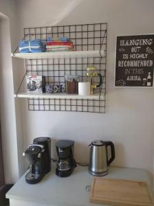 a kitchen counter with a coffee maker and a shelf at 2 bedroom app, close to the beach and Plopsaland in De Panne