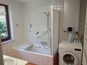 a bathroom with a shower and a washing machine at 2 bedroom app, close to the beach and Plopsaland in De Panne