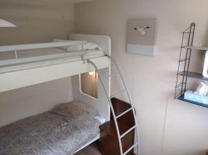 a small room with a bunk bed and a ladder at 2 bedroom app, close to the beach and Plopsaland in De Panne