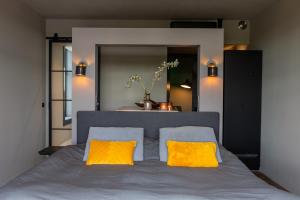 a bedroom with a bed with two yellow pillows at ShortStay Gouda in Gouda