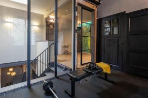 a gym with a treadmill and a glass wall at ShortStay Gouda in Gouda
