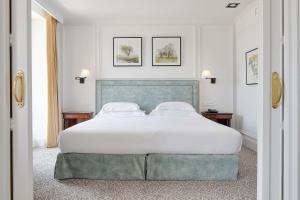sypialnia z dużym łóżkiem z białą pościelą w obiekcie Hotel de Londres y de Inglaterra w mieście San Sebastián