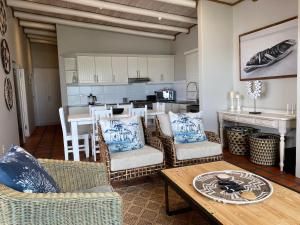 a living room with a table and chairs and a kitchen at C'est la Vie in Paternoster