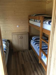 a room with two bunk beds in a cabin at Domki Letniskowe Korsarz in Rowy
