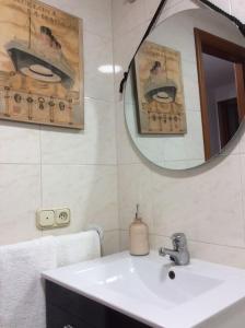 a bathroom with a sink and a mirror at HyP - A Casa do Correo Vello 1ºA / O TEMPO in Pontevedra