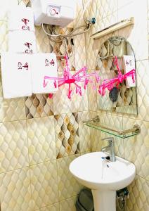 a bathroom with pink bows on the wall at Crystal Apartments Entebbe Uganda Next to UN Base in Entebbe +126 photos