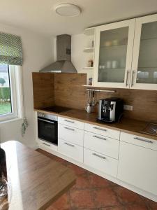 eine Küche mit weißen Schränken und einer Arbeitsplatte in der Unterkunft Haus 1 in Wyk auf Föhr