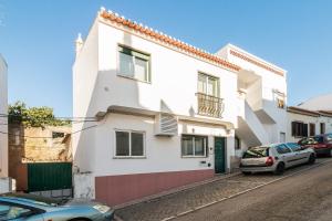 ein weißes Haus mit einem davor geparkt in der Unterkunft Casa Gaivota by Algarve Golden Properties in Lagos