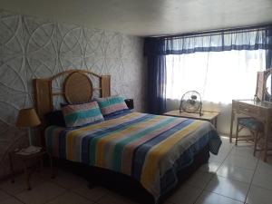 ein Schlafzimmer mit einem Bett mit einer bunten gestreiften Decke in der Unterkunft The Seaside in Scottburgh