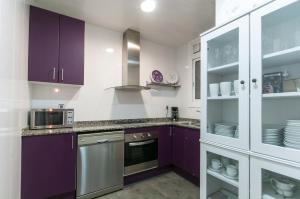 uma cozinha com armários roxos e um micro-ondas em Aribau em Barcelona